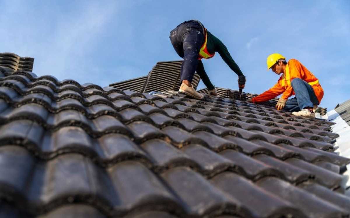 Workers inspecting a pitched tiled roof